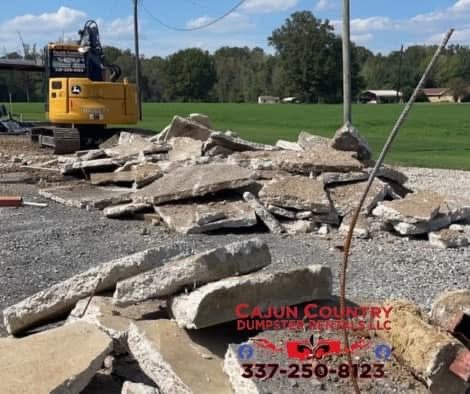 Excavator with broken concrete from a removal project
